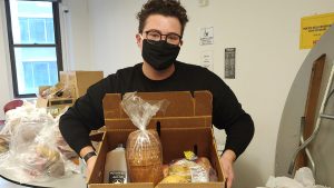 GMHC staff member preparing a box meal for an agency client.