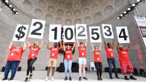 AIDS Walk New York 2023 fundraising total announcement on the Naumburg Bandshell in Central Park.