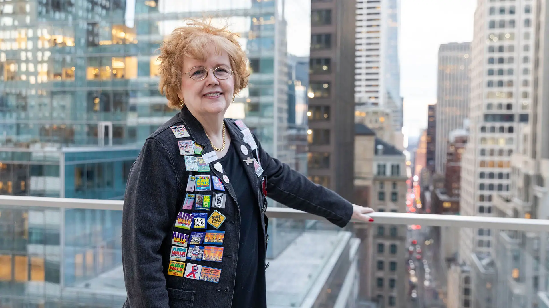 Woman standing on roof wearing jacket with buttons.